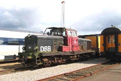 DSB MT 166 photographed in Vojens 22. May 2004.  Built by Frichs, Denmark in a number of 17. The MHT class was put in service in 1958 - 1960. Bo'Bo. Maybach-Mercedes diesel engine 12-cyl. 491 hp. Max speed 90 km/h - 56 mph. Length 12 490 mm. Weight 52,1 metric tonnes. MT 166 was put in service in 1960. Today it is used for work trains. Beside it is the IC4 test train.